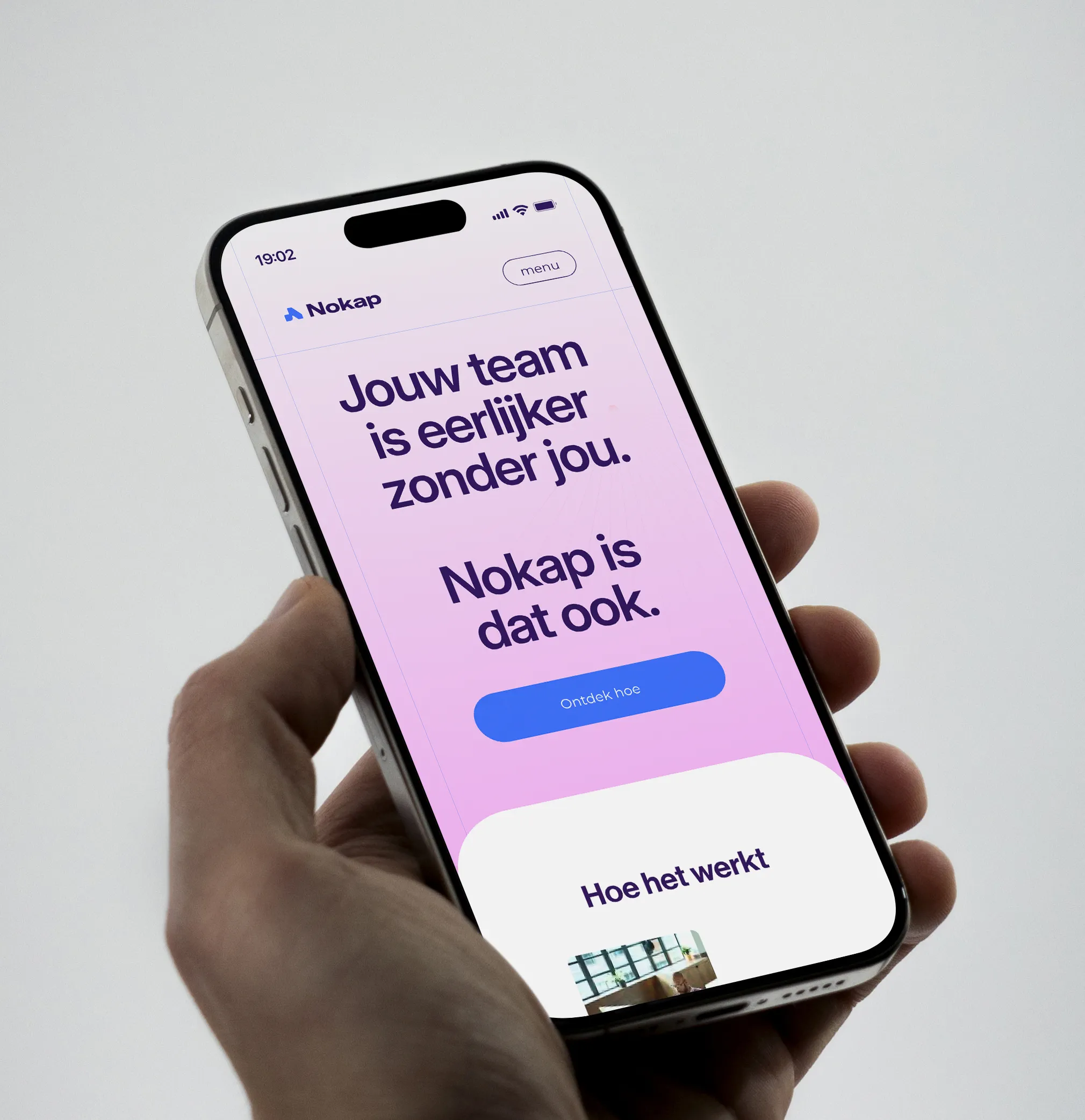 Smartphone in hand met website van Nokap, lichtroze achtergrond en teksten zichtbaar