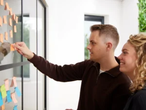 Creatieve brainstormsessie met man en vrouw in een moderne werkruimte.